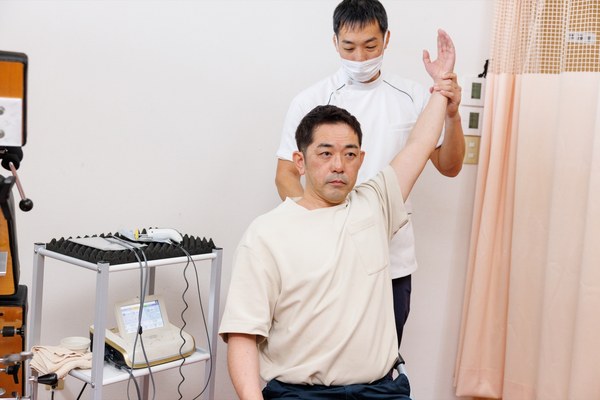 四十肩・五十肩で腕が上がりにくい方の肩の可動域を確認している様子
